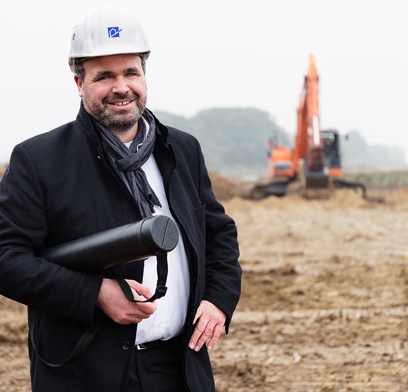 Mann steht vor der Baustelle der Steimker Gärten