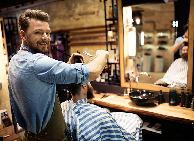 Friseur schneidet einem Mann die Haare