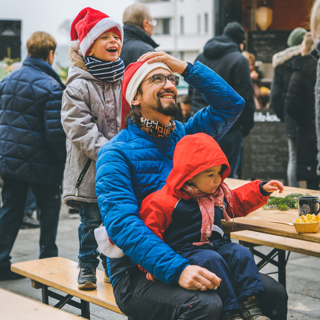 Ein Mann und seine Kinder auf dem Weihnachtsmarkt in den Steimker Gärten