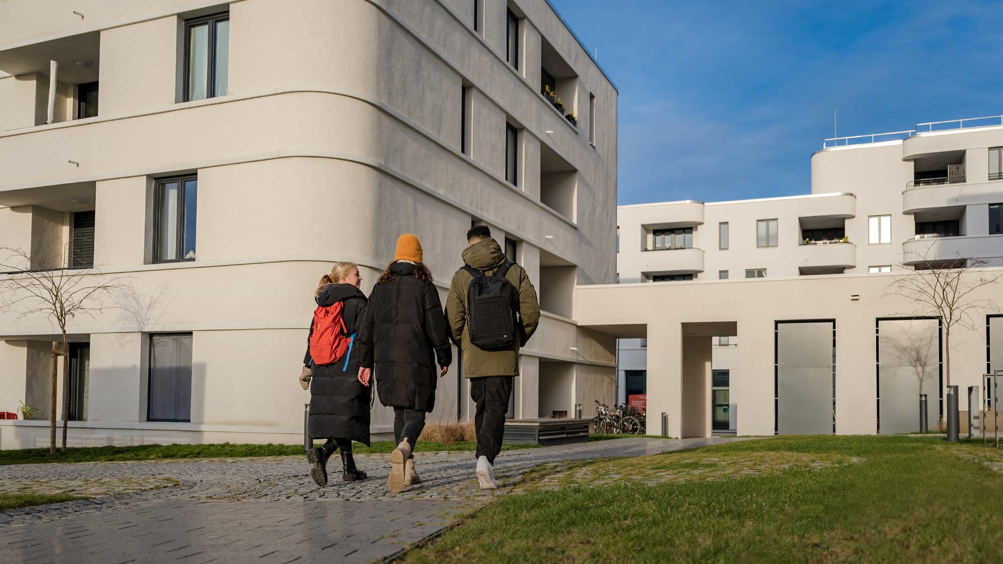 Drei junge Leute gehen durch die Steimker Gärten