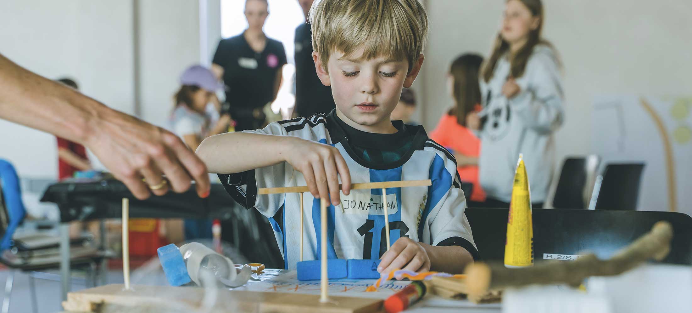 Workshop Kletterspielplatz. Ein Junge baut ein Modell für ein Klettergerüst.