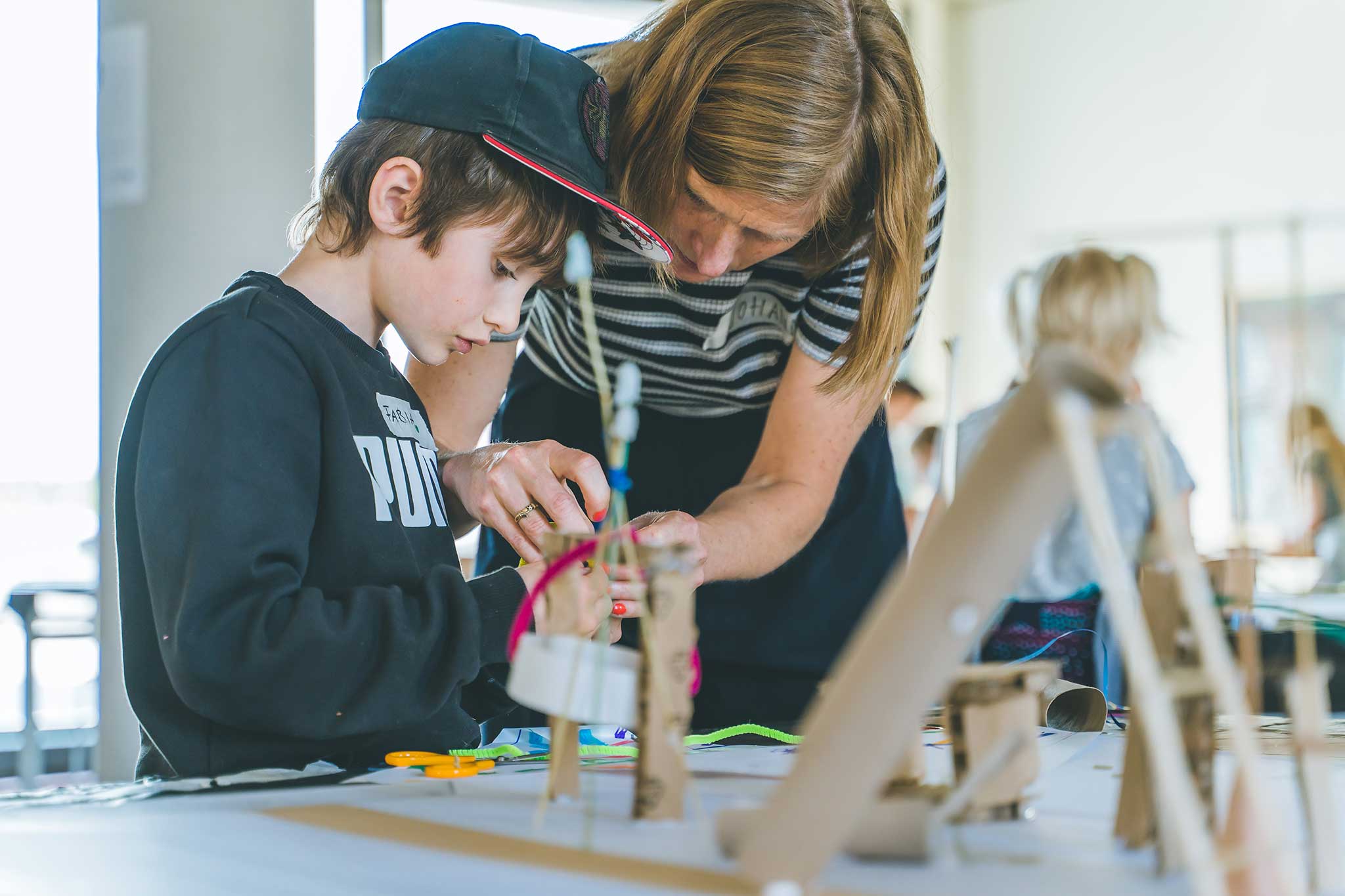 Workshop Kletterspielplatz. Ein Junge baut ein Modell für ein Klettergerüst.