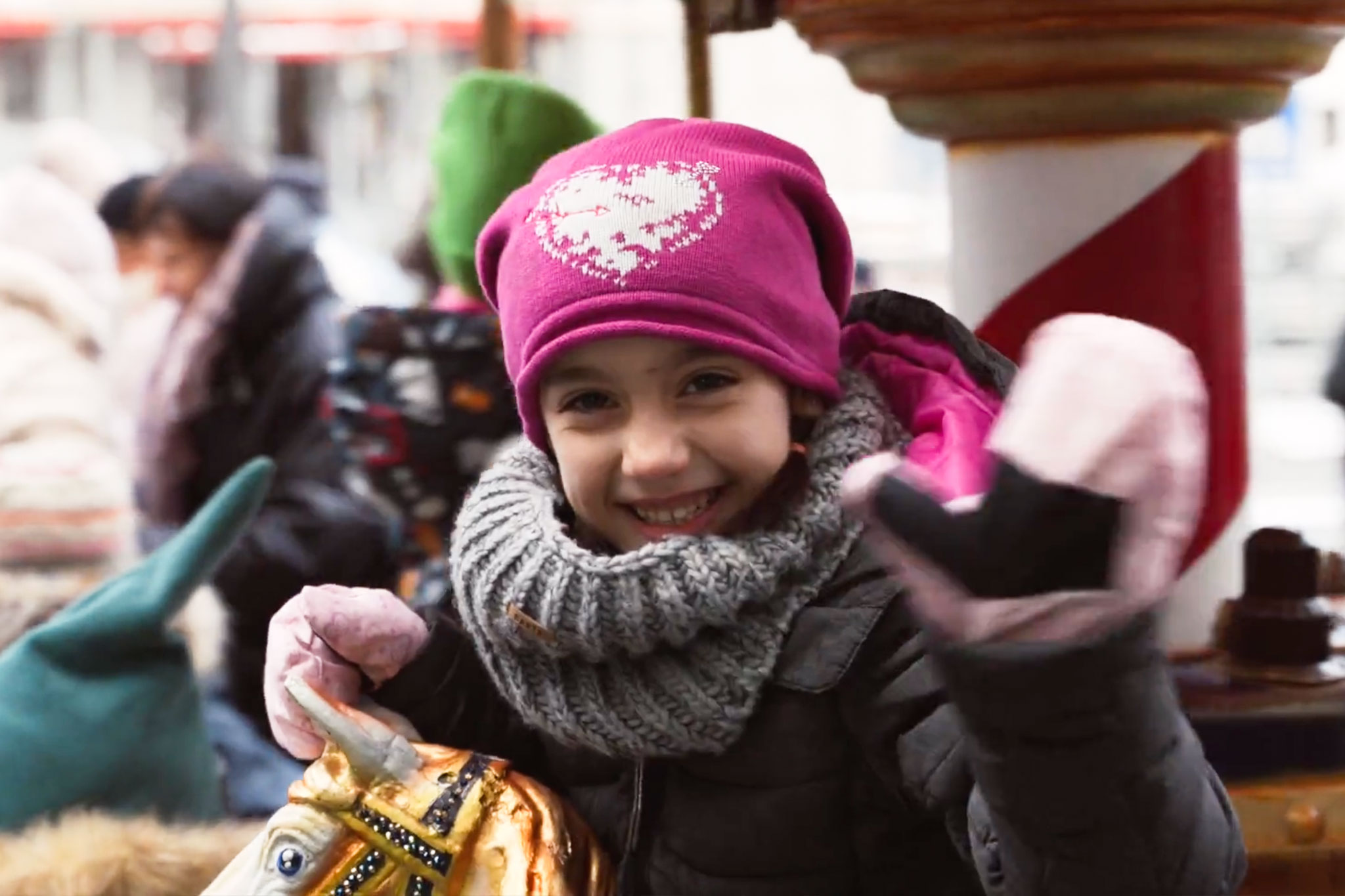 Ein Mädchen winkt auf dem Karrussel auf dem Weihnachtsmarkt