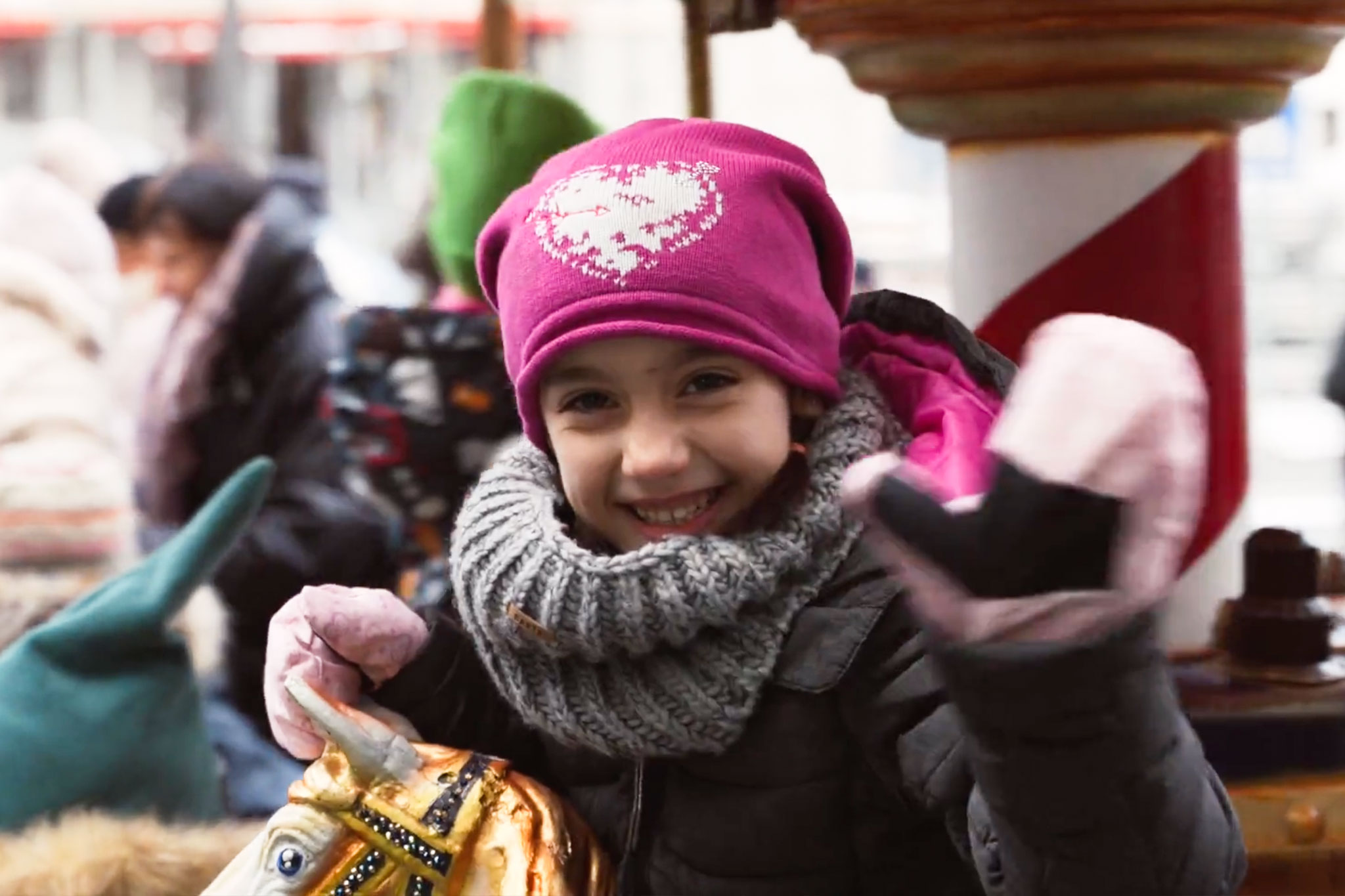 Ein Mädchen winkt auf dem Karrussel auf dem Weihnachtsmarkt