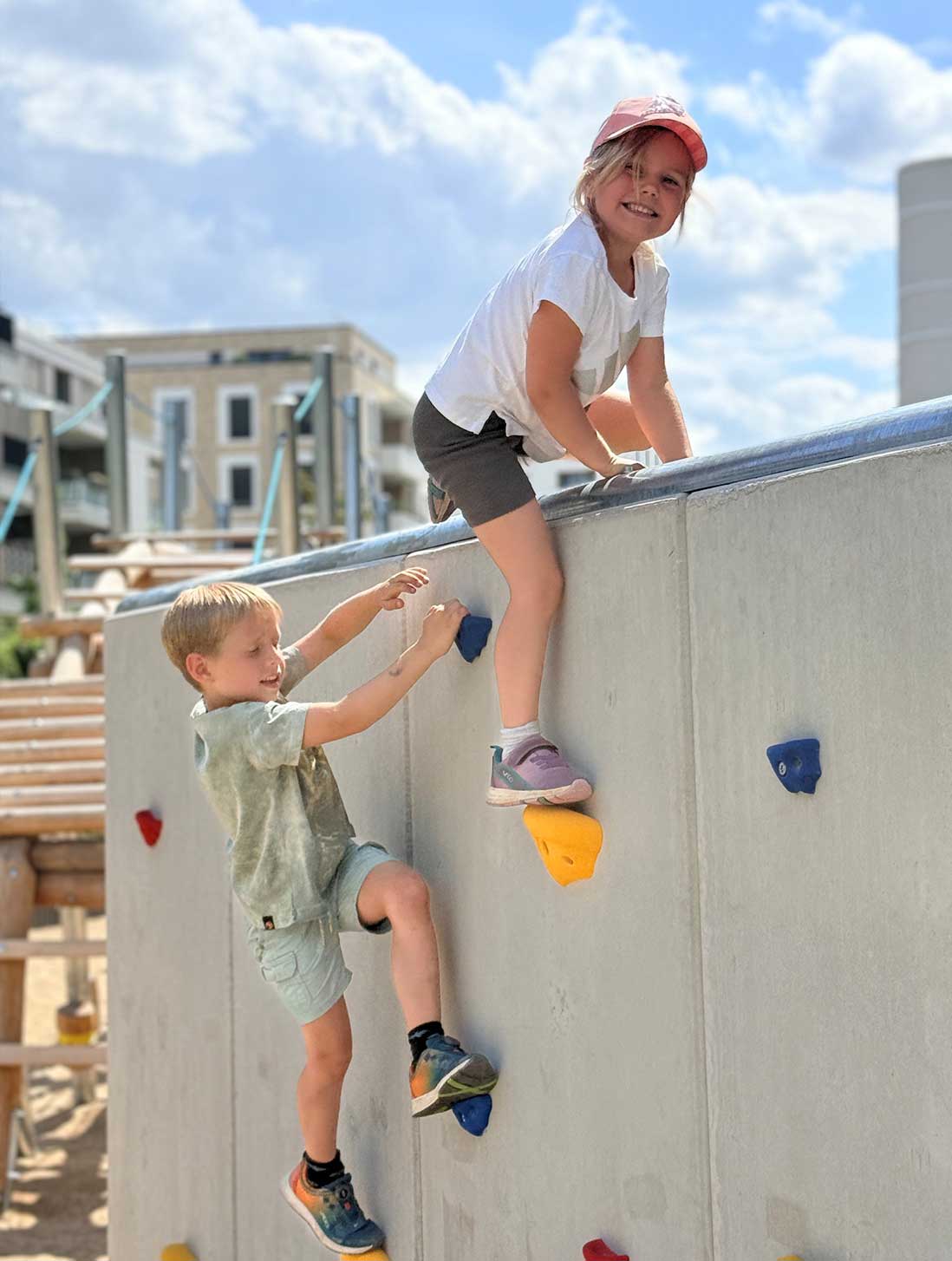 Kinder an einer Kletterwand auf dem kletterspielplatz