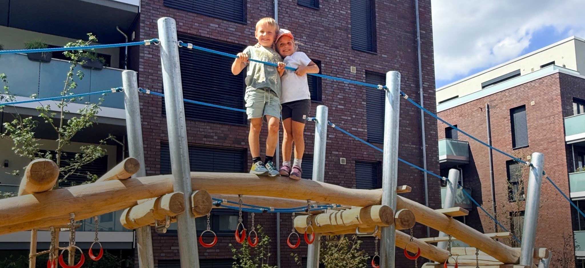 Kinder auf dem neu eröffnetem Kletterspielplatz